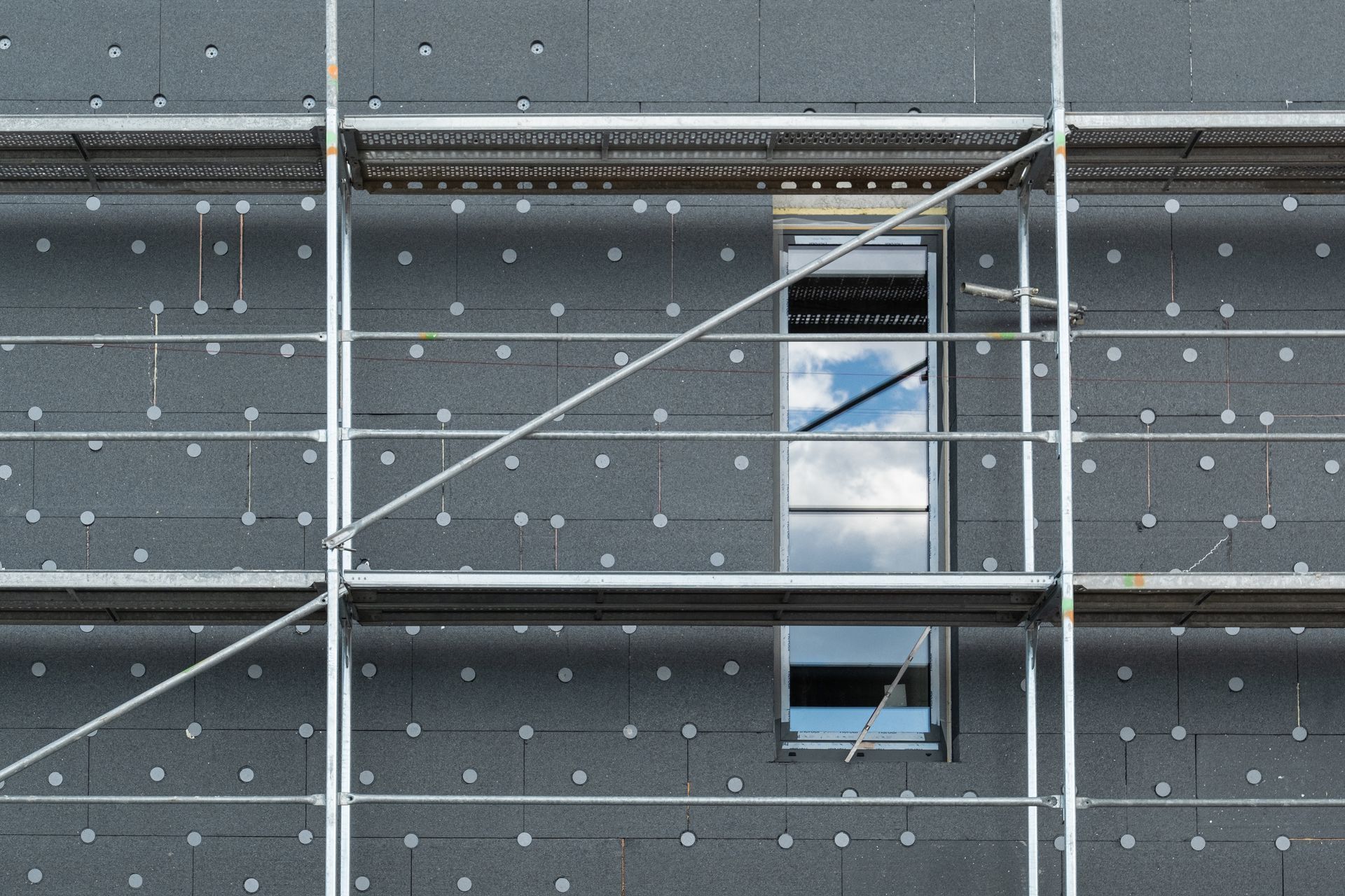 Une façade avec un échafaudage et des panneaux de polystyrène