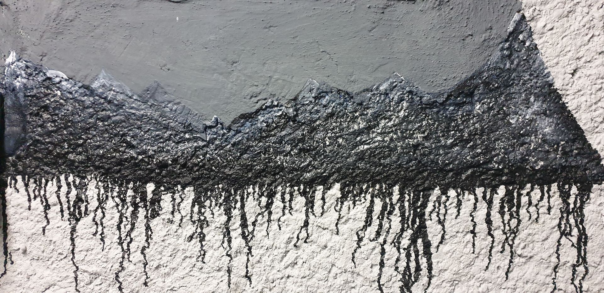 Une peinture en noir et blanc d'une chaîne de montagnes avec des arbres au premier plan.