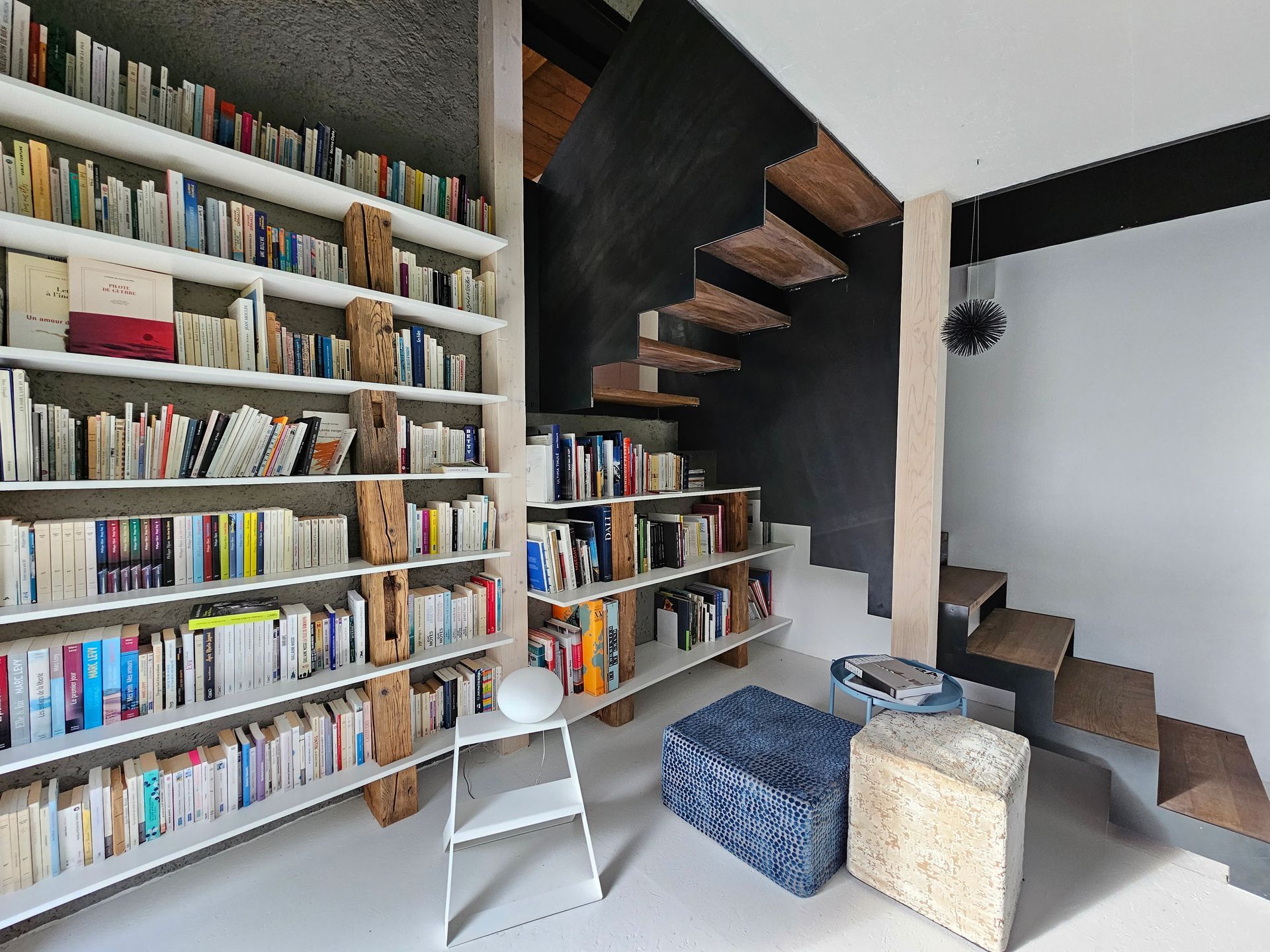 Une bibliothèque avec un escalier et beaucoup de livres sur des étagères