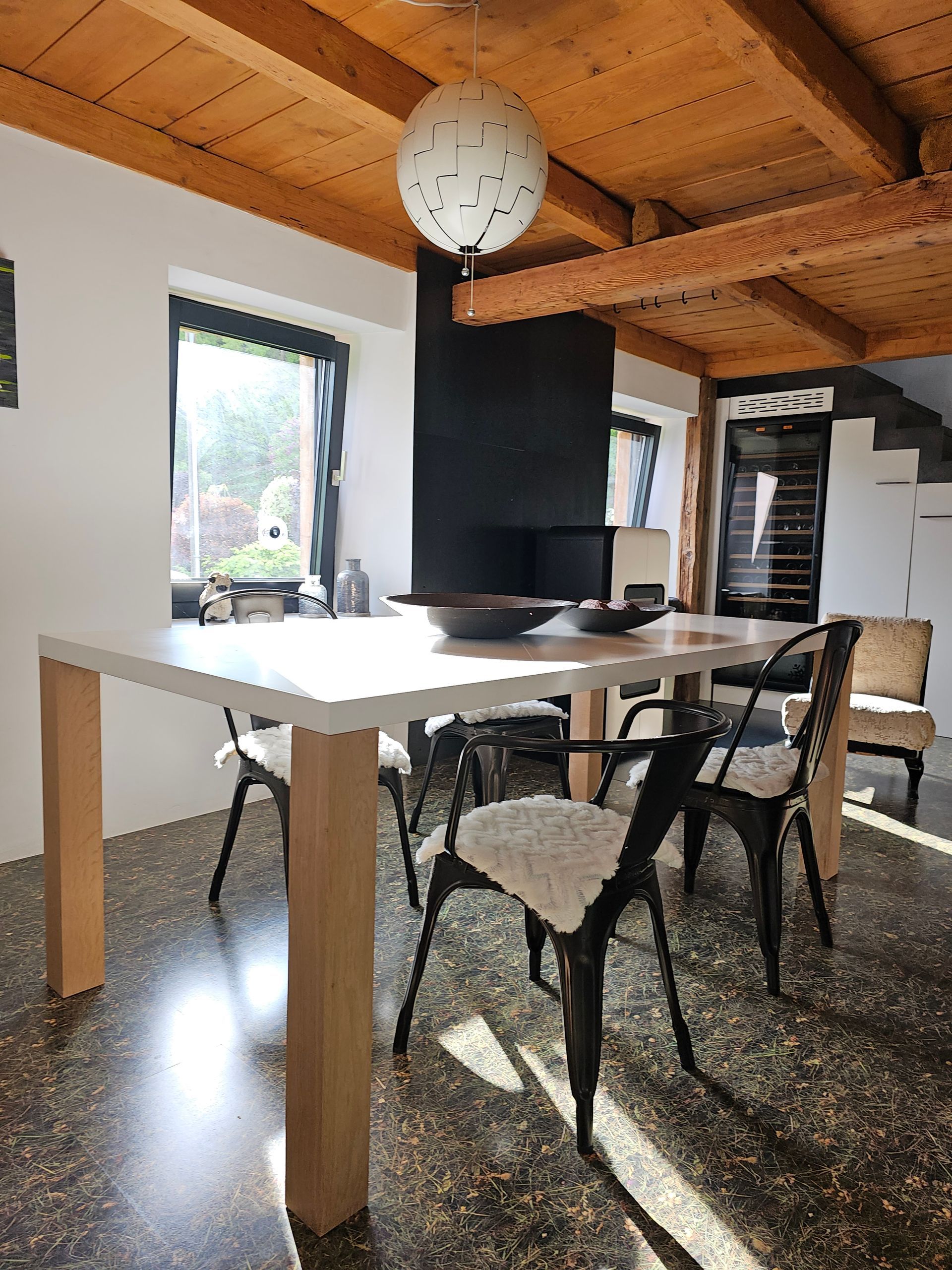 Une salle à manger avec une table et des chaises sous un plafond en bois