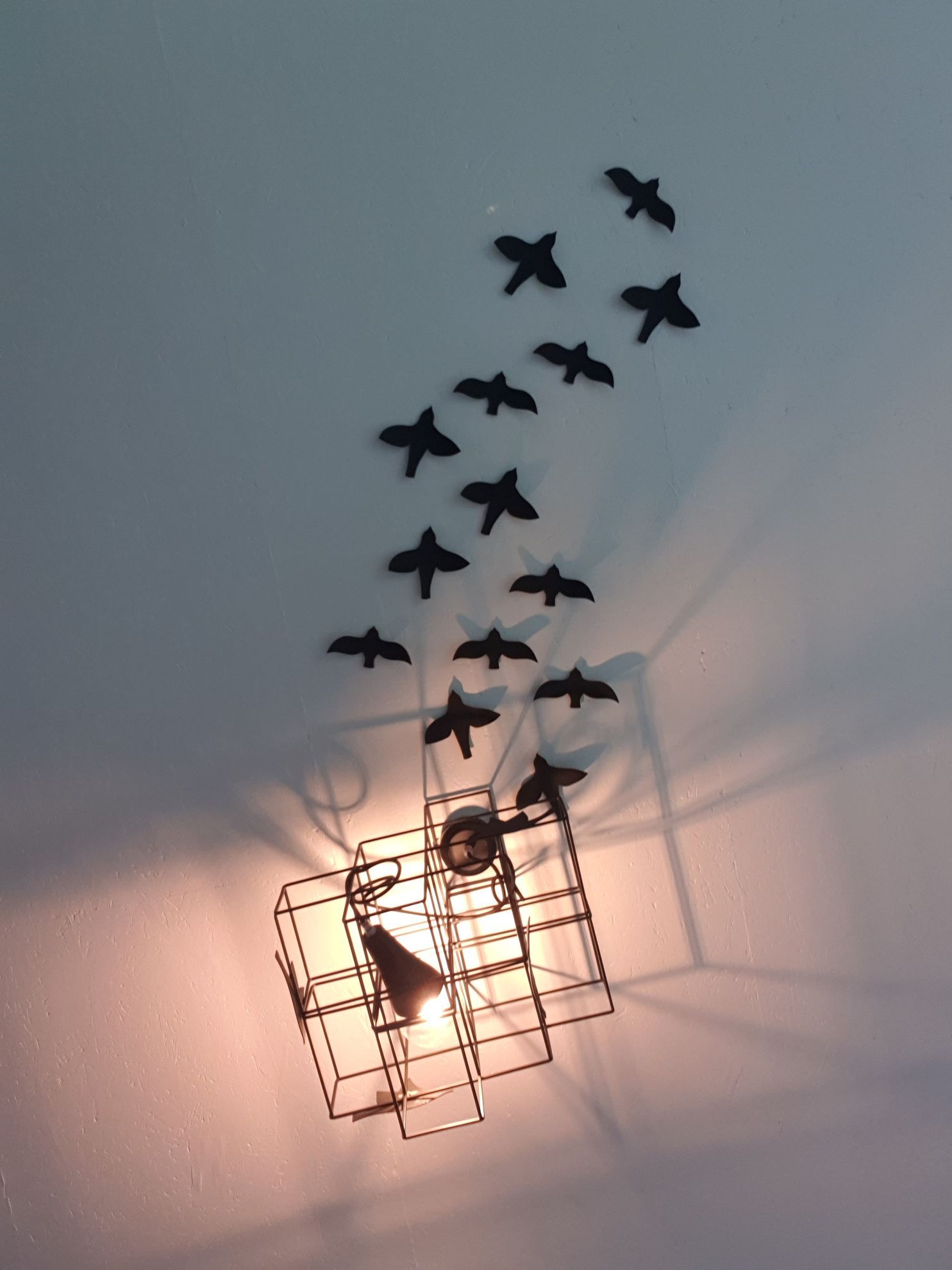 Une volée d'oiseaux noirs volent autour d'une lumière