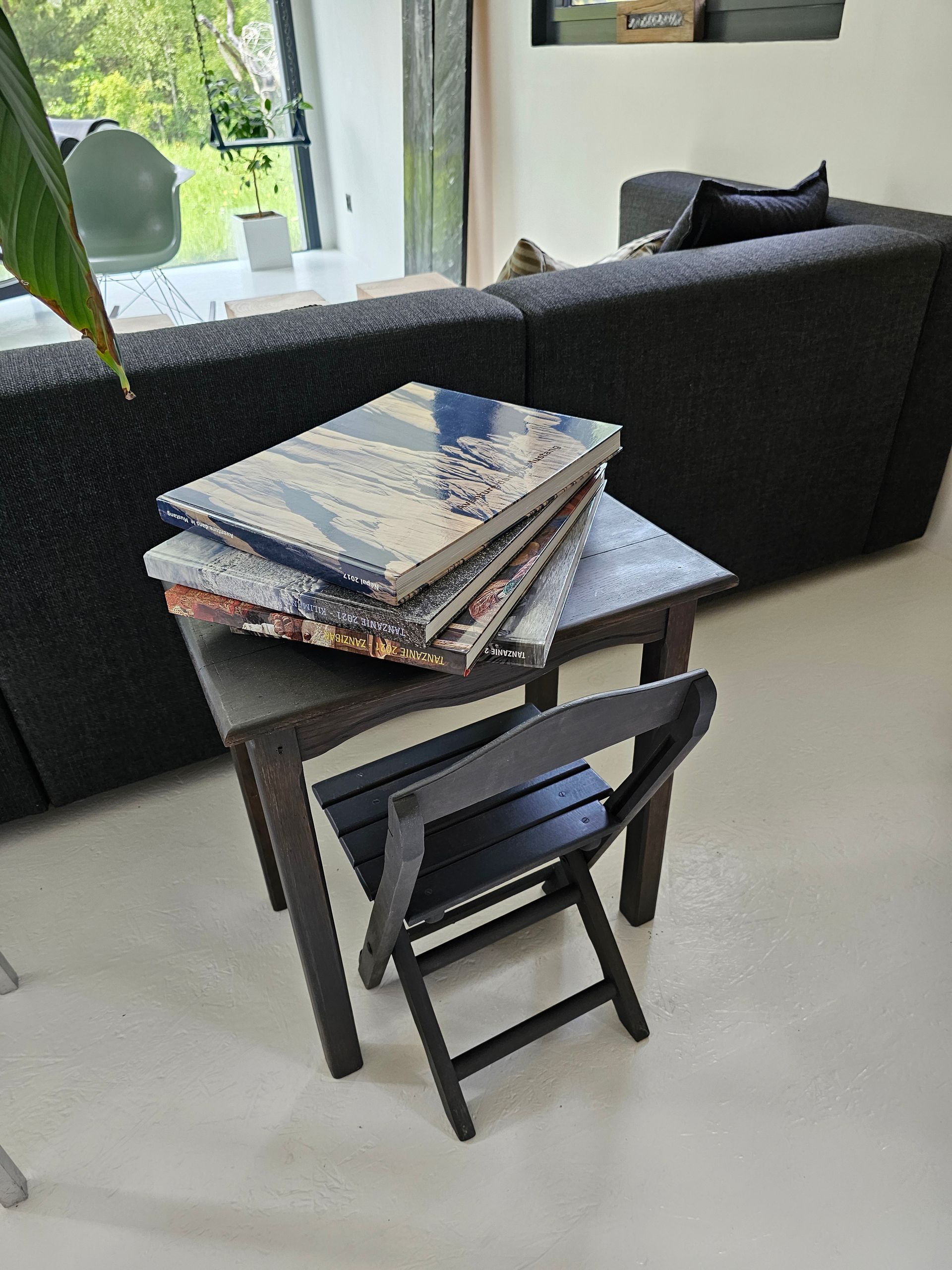 Une pile de livres se trouve sur une petite table dans un salon.
