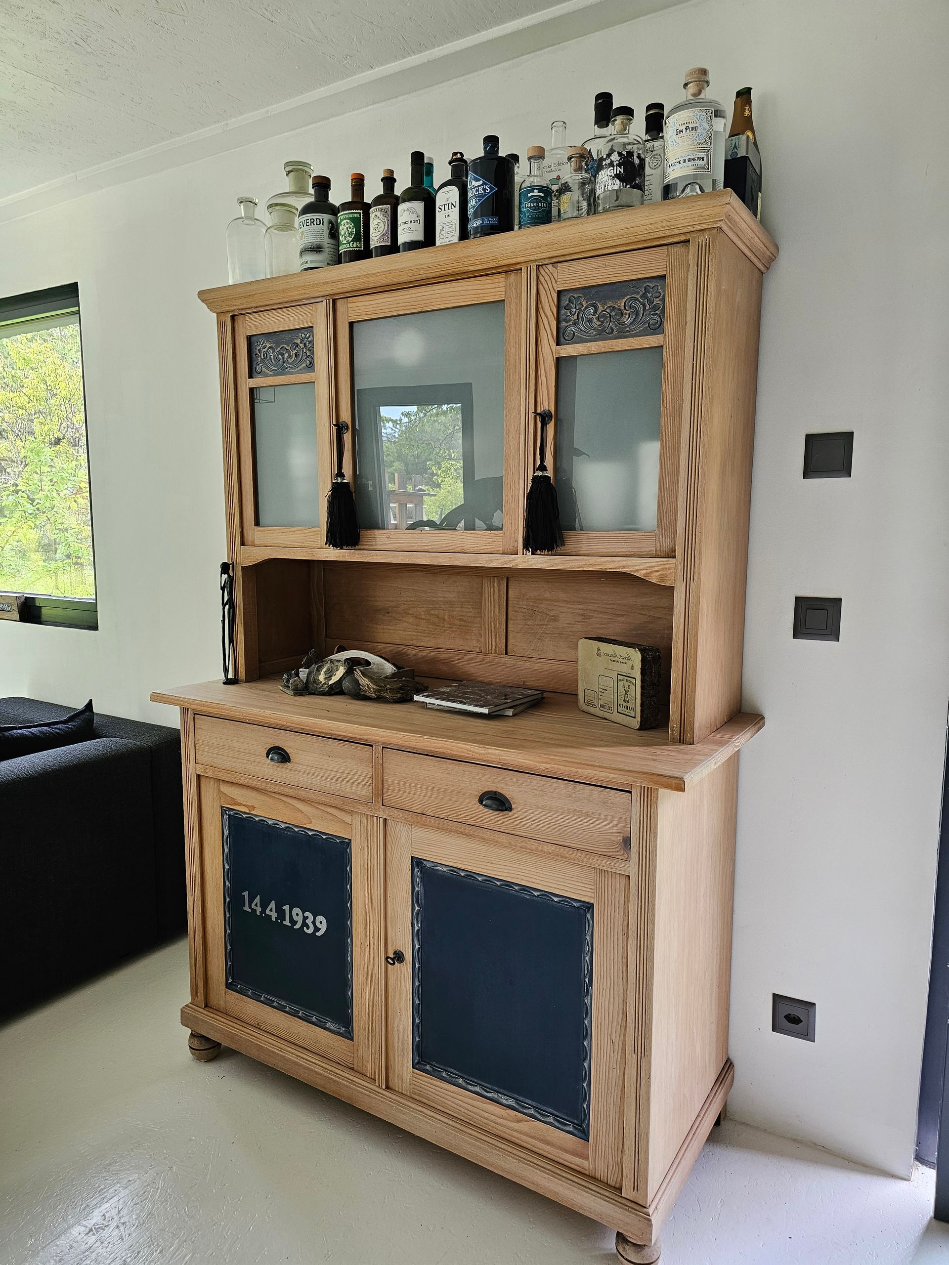 Une armoire en bois avec des bouteilles dessus dans un salon.