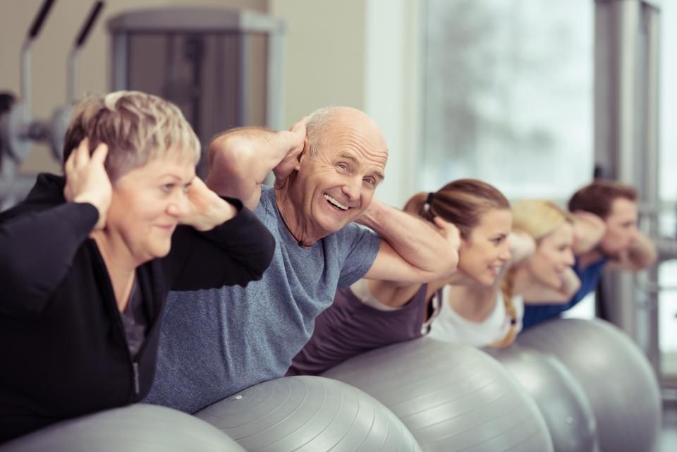 PV Gesundheitstraining - Frau in Sportkleidung sitzt auf dem Boden und streckt und massiert ihr Bein