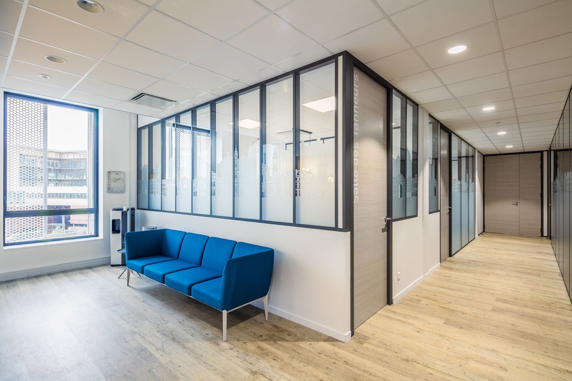 Canapé bleu derrière des bureaux d'une entreprise