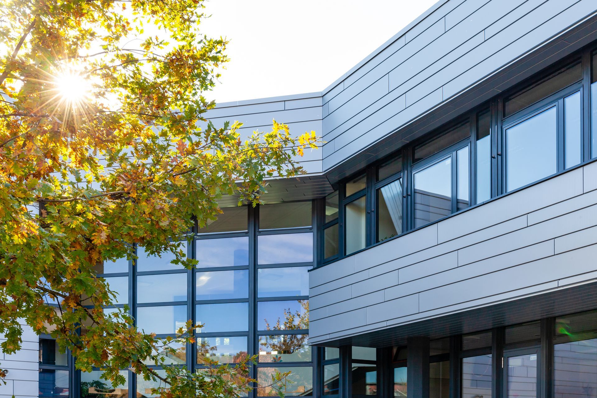 Façade d'un bâtiment à plusieurs étages avec plusieurs fenêtres et baies vitrées