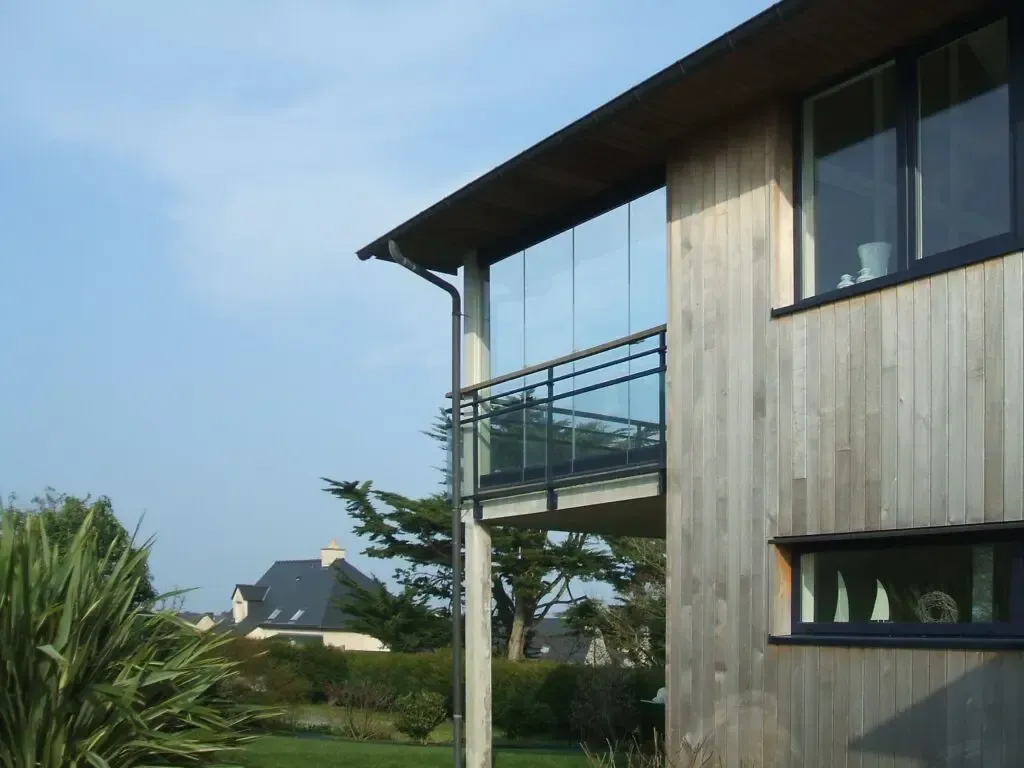 Maison avec un bardage en bois et un balcon