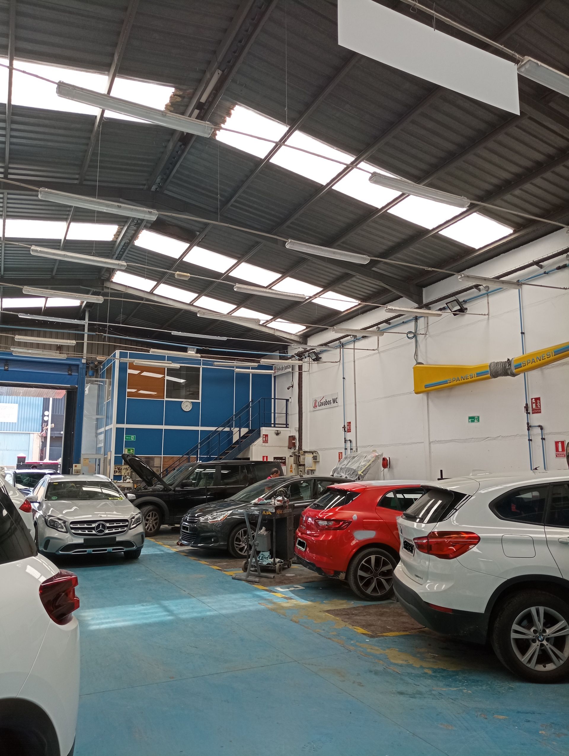 Hay muchos coches aparcados dentro de un garaje.