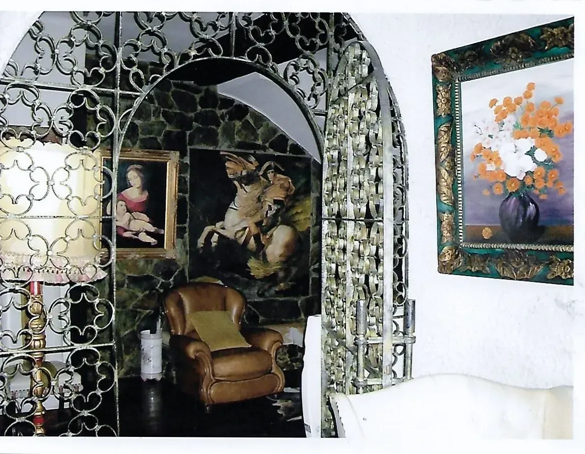 Una habitación con una silla y un cuadro en la pared.