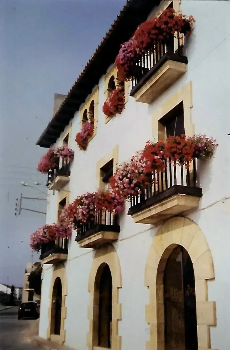 Un edificio blanco con balcones llenos de flores.