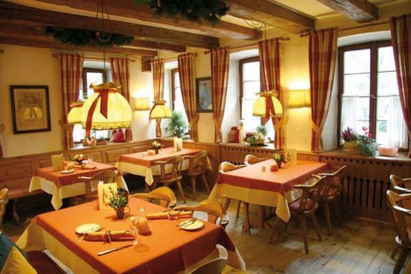 Ein Restaurant mit vielen Tischen und Stühlen und Lampen