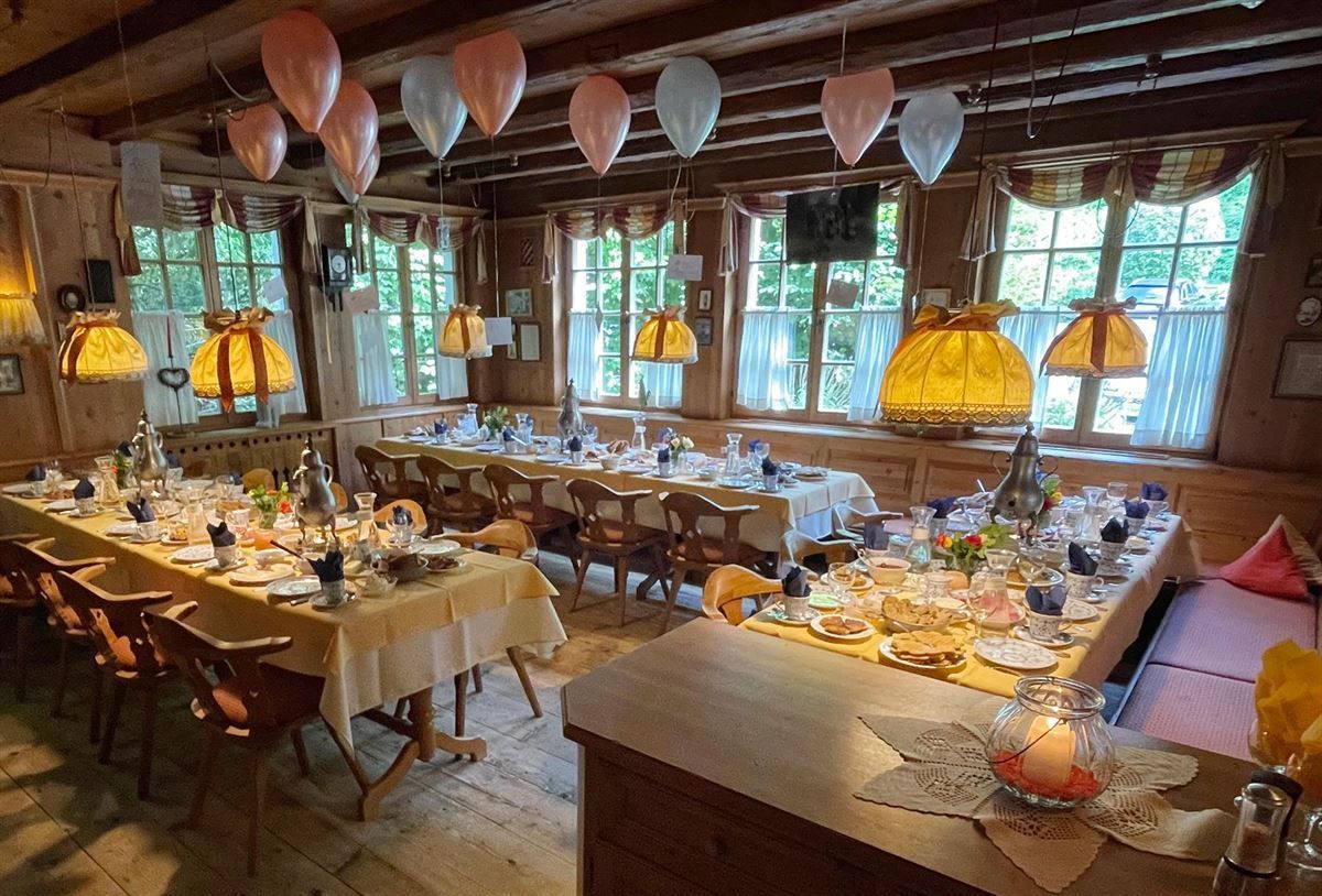 Ein Restaurant mit Tischen und Stühlen und Luftballons, die von der Decke hängen