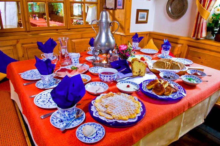 Ein Tisch mit Tellern voller Essen und lila Servietten darauf