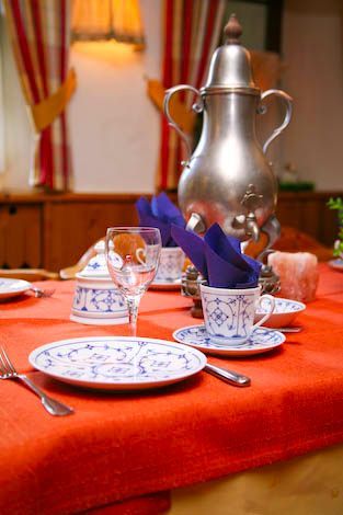 Ein Tisch mit Tellern, Tassen, Gläsern und Besteck darauf
