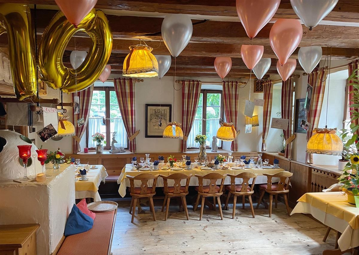 Ein Raum mit Tischen und Stühlen und Luftballons mit der Zahl 10