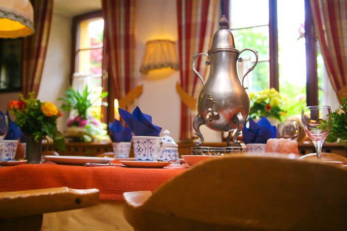 Ein Tisch mit Tellern und einer silbernen Teekanne darauf