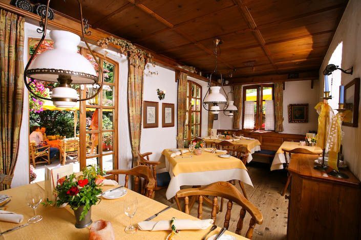 Ein Esszimmer mit Tischen und Stühlen und einer Vase mit Blumen auf dem Tisch