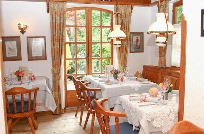 Ein Esszimmer mit Tischen und Stühlen und einem Fenster