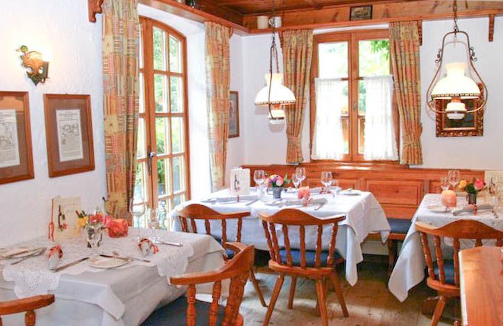 Ein Esszimmer mit Tischen und Stühlen und einem Fenster