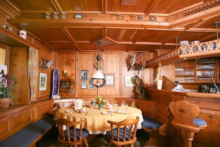 Ein Esszimmer aus Holz mit einem runden Tisch und Stühlen