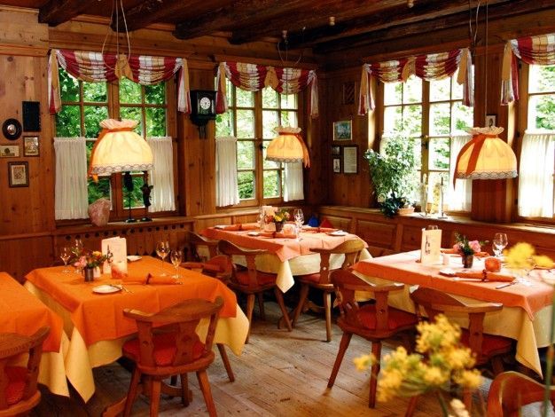 Ein Esszimmer mit Tischen und Stühlen und von der Decke hängenden Lampen