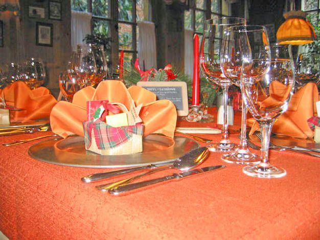 Ein für ein Abendessen gedeckter Tisch mit einem kleinen Korb darauf