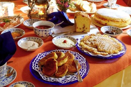 Ein Tisch mit Tellern voller Essen, darunter Pfannkuchen und Kuchen