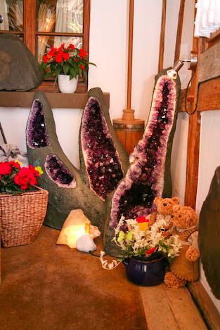 Ein Teddybär sitzt neben einem großen lila Felsen