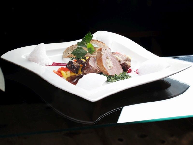 Ein weißer Teller mit Fleisch und Gemüse darauf