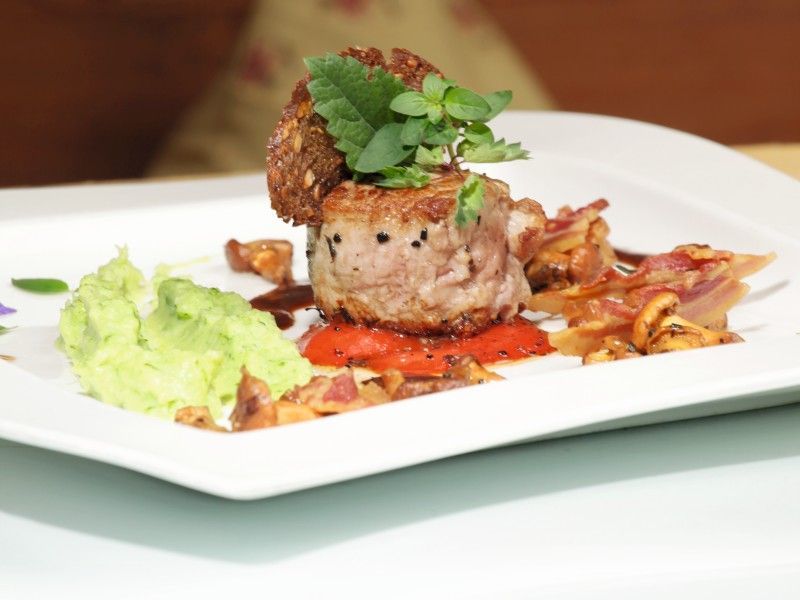 Ein weißer Teller mit Fleisch und Kartoffelpüree