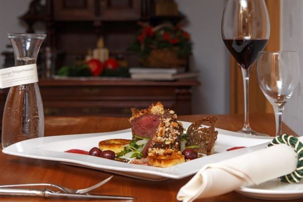 Ein Teller mit Essen und ein Glas Wein auf einem Tisch