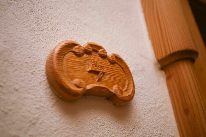 Eine Nahaufnahme einer Holzschnitzerei an einer weißen Wand.
