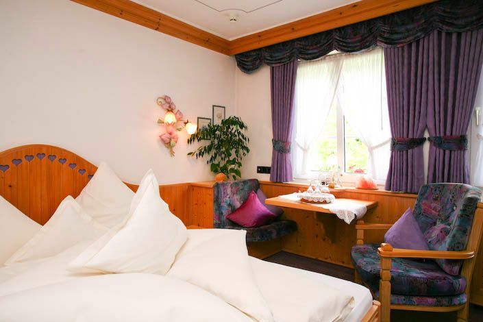 Ein Schlafzimmer mit einem Bett, einem Stuhl und einem Fenster