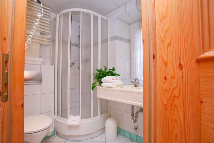 Ein Badezimmer mit Toilette, Waschbecken und Duschkabine