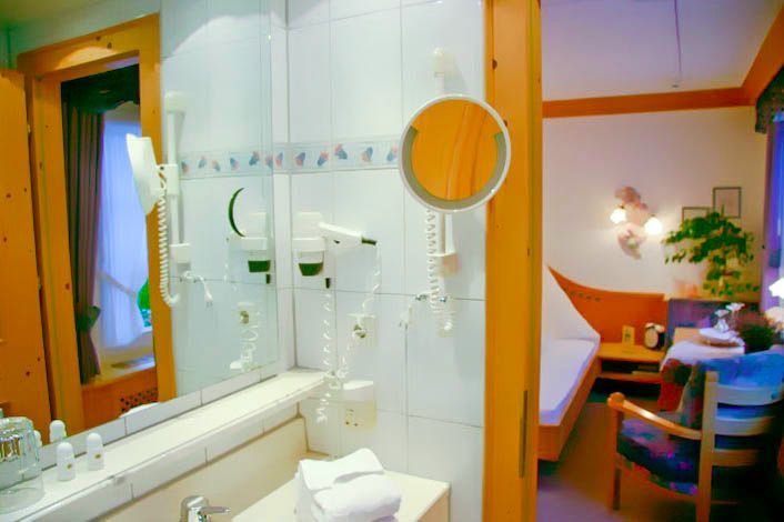 Ein Badezimmer mit Spiegel und Haartrockner