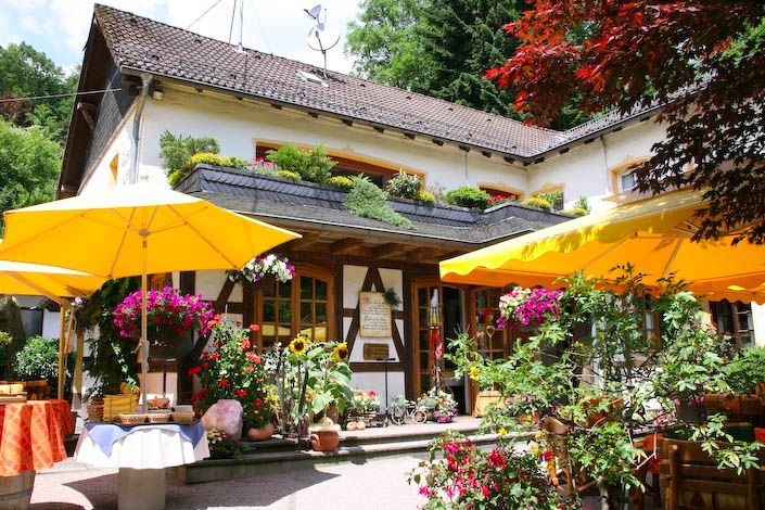 Ein weißes Gebäude mit gelben Sonnenschirmen davor