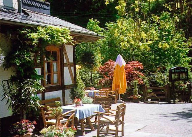 Ein Tisch und Stühle vor einem Haus mit einem gelben Sonnenschirm