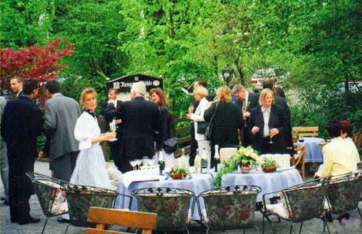 Eine Gruppe von Menschen steht um Tische und Stühle herum