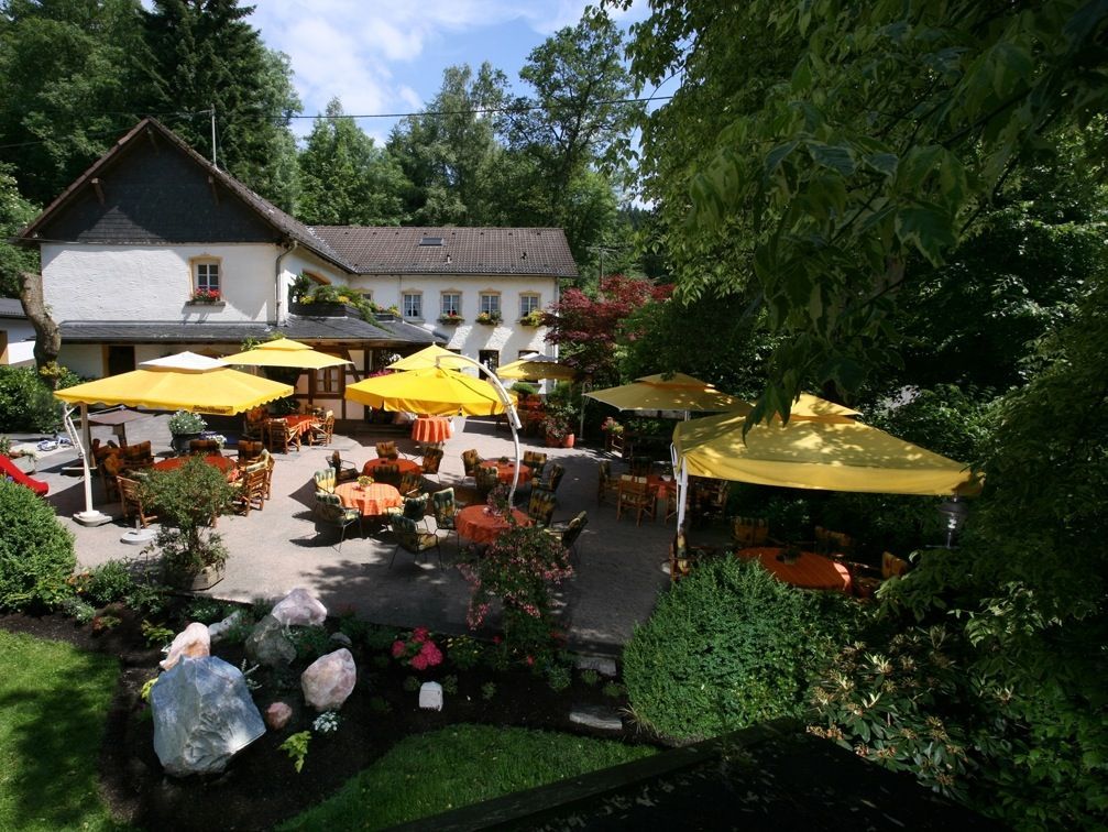 Ein Restaurant mit gelben Sonnenschirmen und Tischen davor