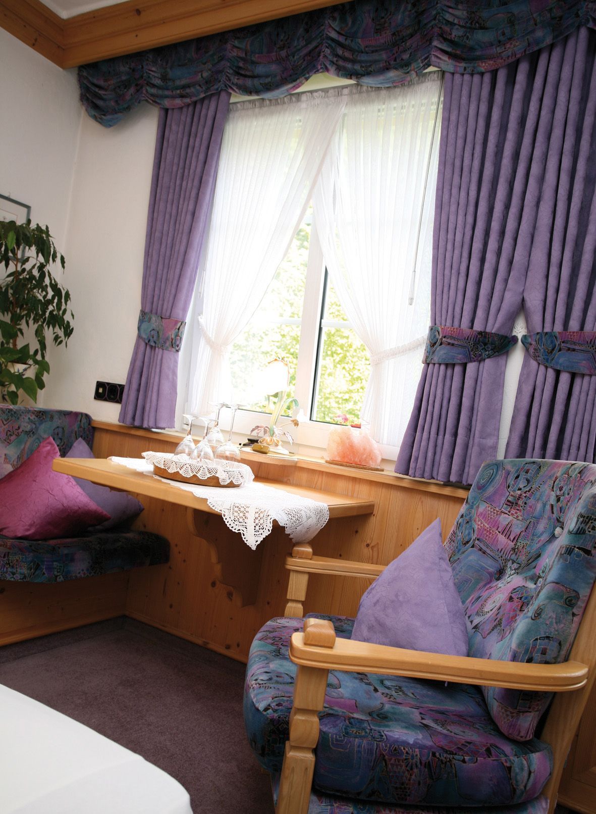 Ein Wohnzimmer mit lila Vorhängen und einem Stuhl