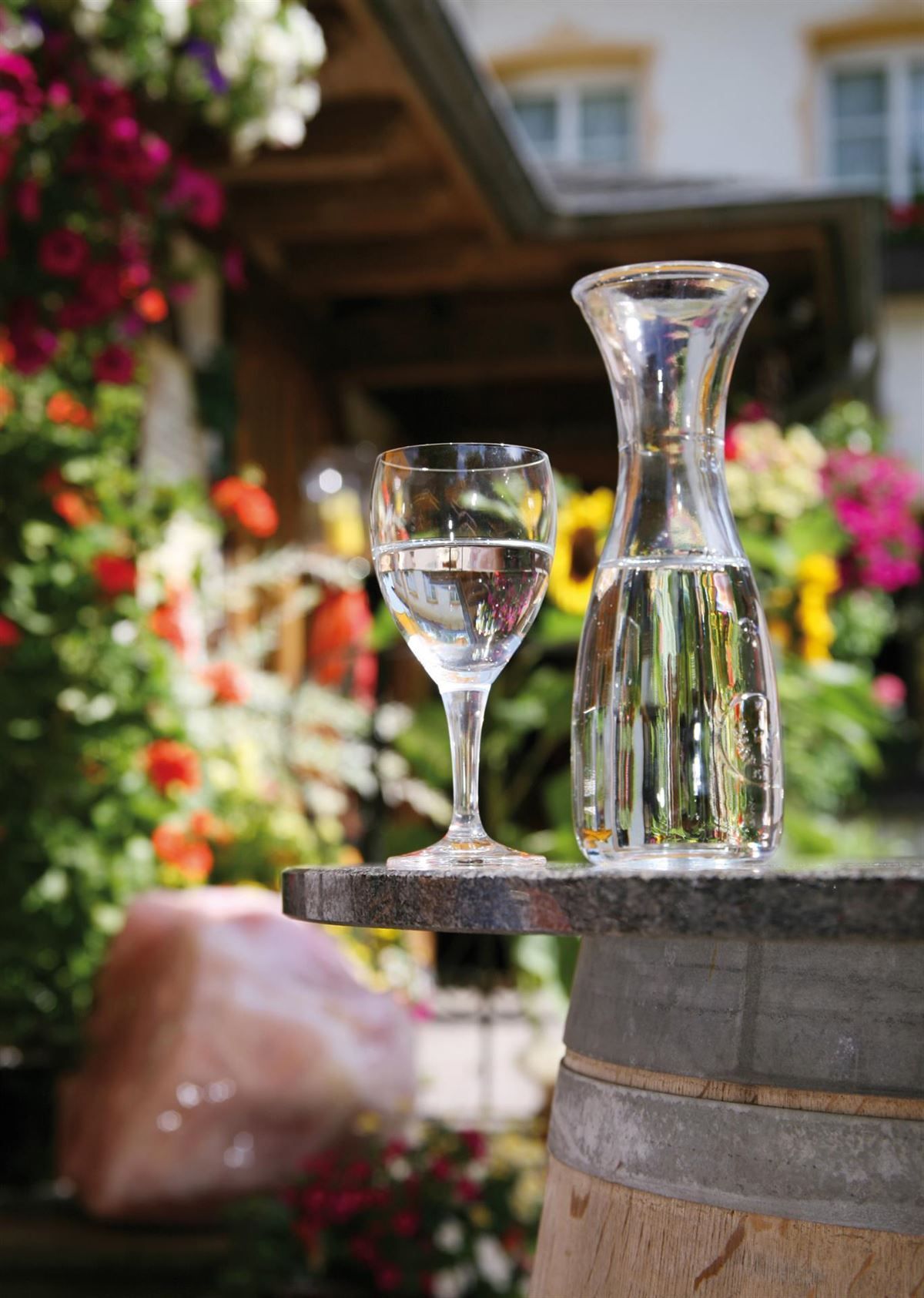 Ein Glas und ein Krug Wasser auf einem Fass