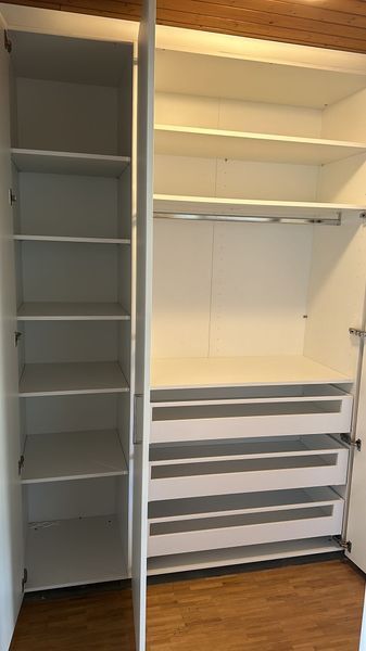 Un placard avec beaucoup d'étagères et de tiroirs dans une pièce.