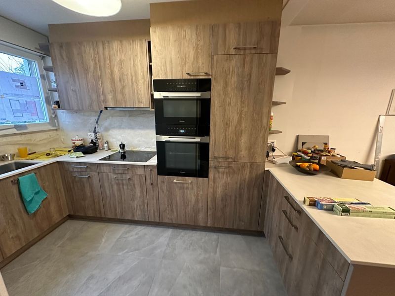 Une cuisine avec des armoires en bois, un évier et un four.