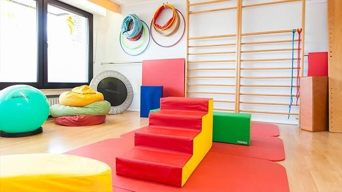 Ein Fitnessstudio voller bunter Spielsachen und Bälle.