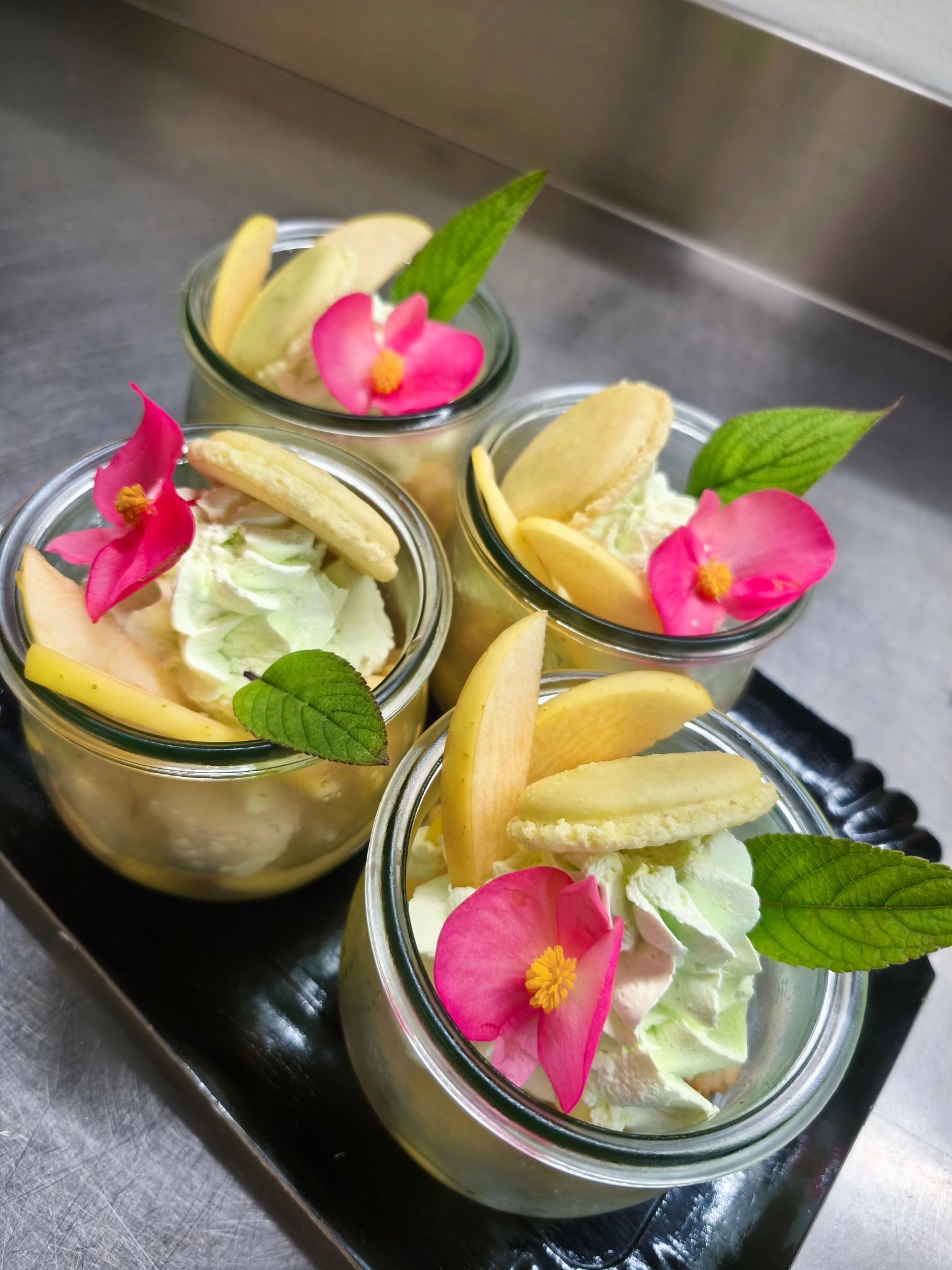 Un gâteau en forme de huit, décoré de macarons jaunes, de volutes de glaçage bleu, de chocolat et de biscuits.