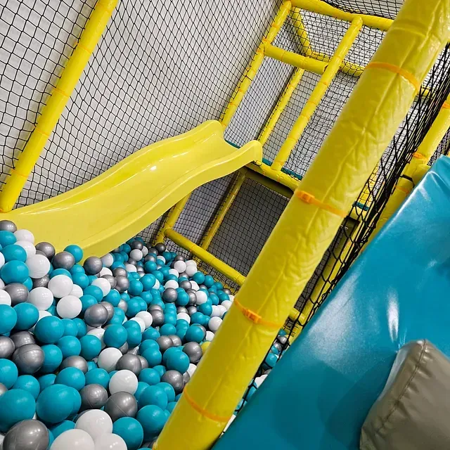 Un tobogán en una piscina de pelotas con pelotas azules y blancas.