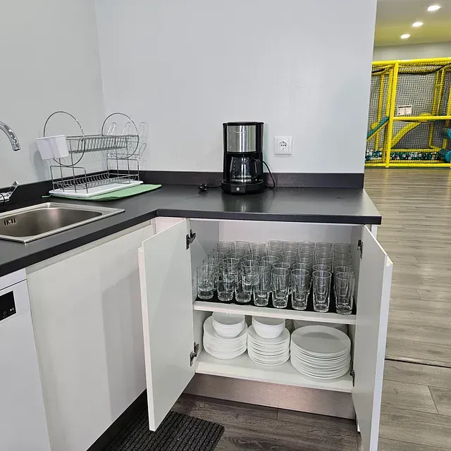 Una cocina con platos, cuencos, vasos y una cafetera.