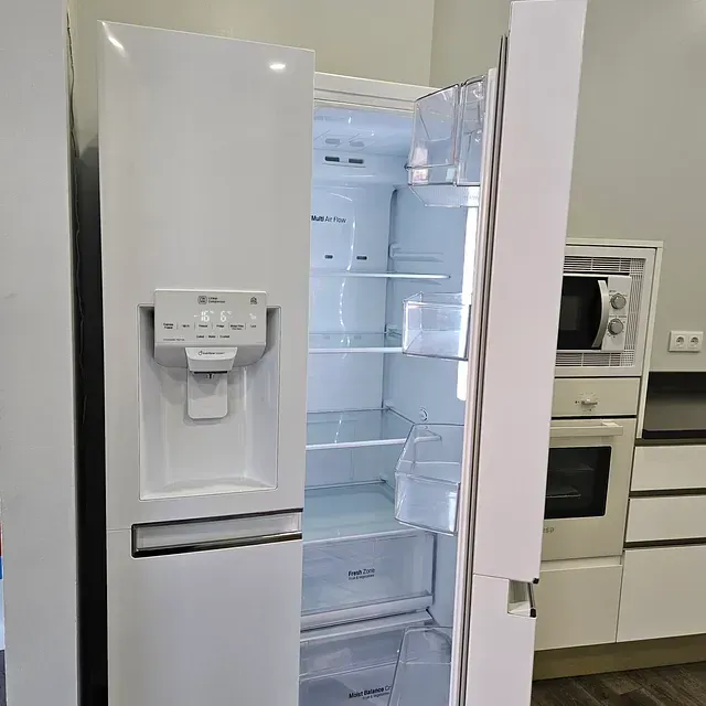 Un refrigerador blanco con la puerta abierta en una cocina.