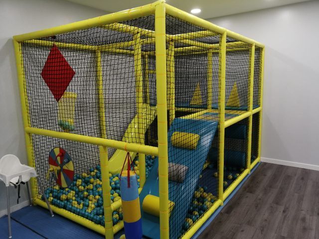 Un patio de recreo con muchas pelotas amarillas y azules.