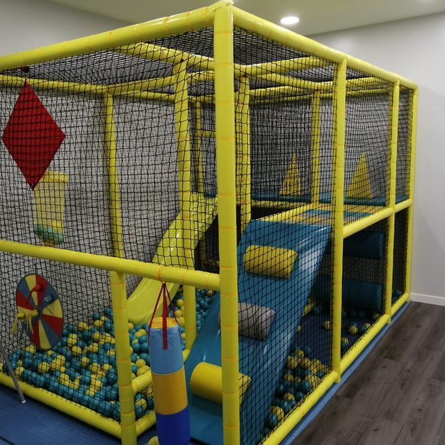 Una gran jaula amarilla llena de bolas azules y amarillas